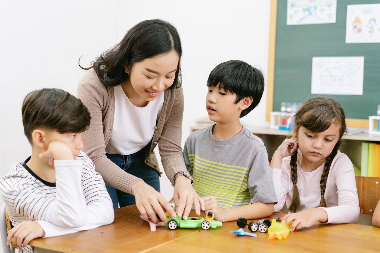 Group of Elementary Age Schoolchildren and and Female teacher making electronic toys at the school